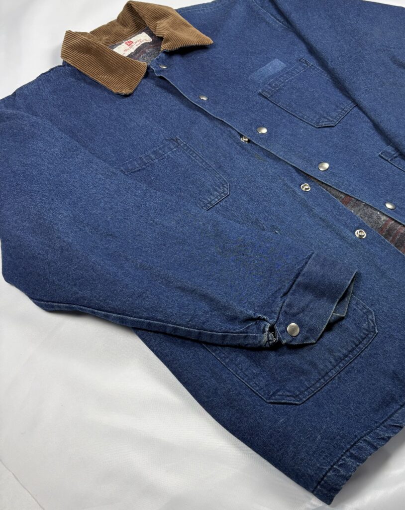 Angled front view of an estimated late 1980s to early 1990s Adolphe Lafont denim work jacket with corduroy collar and patch pockets.